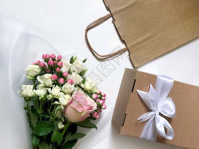 粉红色背景上的粉红色花朵工艺纸袋和盒子客户送货服务包图片