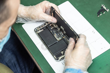 在修理车间修理智能电话的技术师其修补技图片
