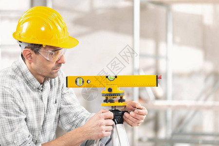 建造者结构工程师建筑师或戴安全帽的工人在建筑物的三脚架背景图片