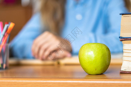 书架彩色铅笔和苹果配在木桌上图片