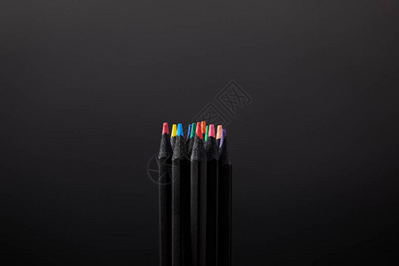 黑墙背景上排列好的铅笔的特写视图背景图片