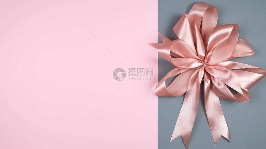 彩色背景上的粉红色缎面蝴蝶结装饰背景顶视图文本空图片