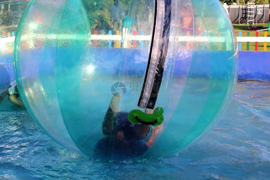 儿童在游泳池水上漂浮的充气球里玩图片