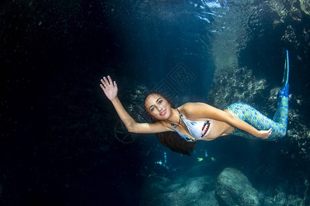 美人鱼在深蓝海水下游泳用潜水图片
