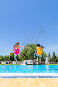 两个女孩跳进游泳池图片