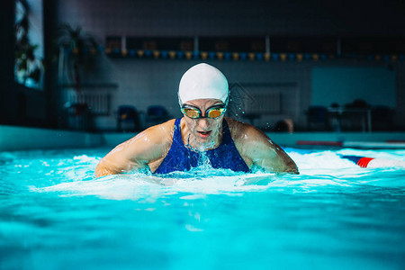 专业女子在黑暗背景上使用乳房操控技术游泳背景图片