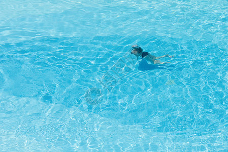 对游泳池里男孩的空中观察带有透明的蓝图片
