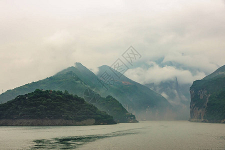 长江上的瞿塘峡从绿色山坡下降的朦胧cloudscape到峡谷的广阔视野景观背景图片