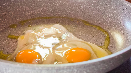 在煎锅上用橄榄油煎有机鸡蛋图片