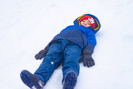 小男孩躺在雪地上图片