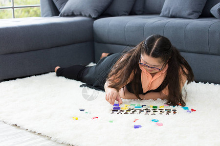 自闭症可爱女孩在家里练习连接颜色棒自闭症或失语症儿童智力恢图片