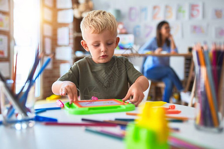 年轻的白种人孩子和老师在幼儿园玩耍图片