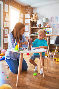 年轻的白种人孩子和老师在幼儿园玩耍母子在游戏室图片