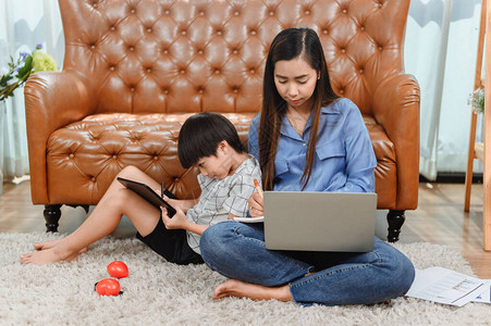 亚洲妈在家工作妈和儿子在一起孩子在线学习教育新的正常生活方图片