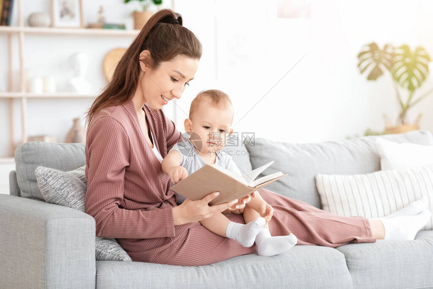 爱护妈阅读书向她可爱的在家的婴儿男孩大声宣读图片