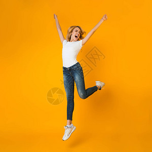女人在橙色背景上玩得开心跳图片