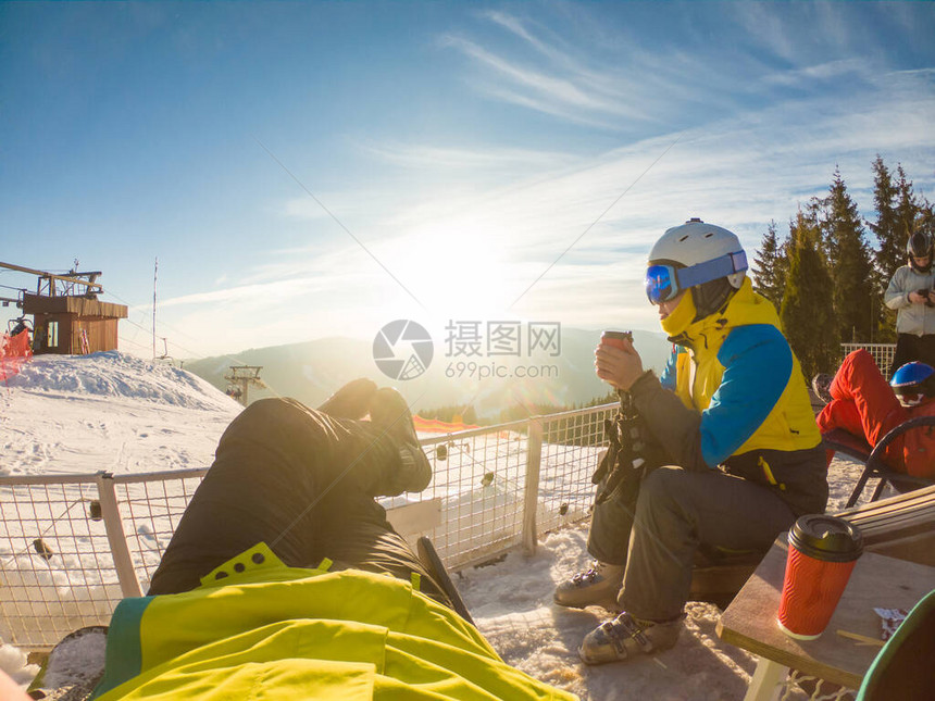 在雪山顶休息的情侣喝热茶滑雪和滑雪图片