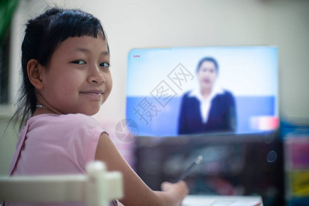 在家学习DLTV或远程学习电视的小女孩隔离期间的社交距离图片