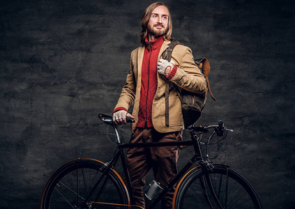 穿着红色毛衣的现代大胡子时髦者正拿着他的自行车图片
