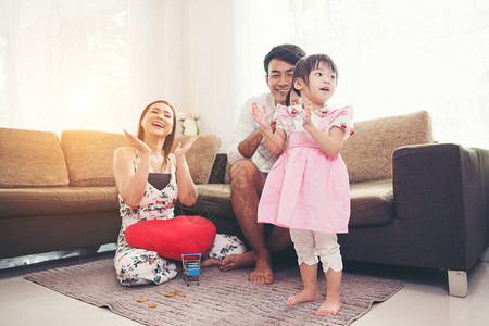 孩子和她的父母在客厅的地板上玩耍图片