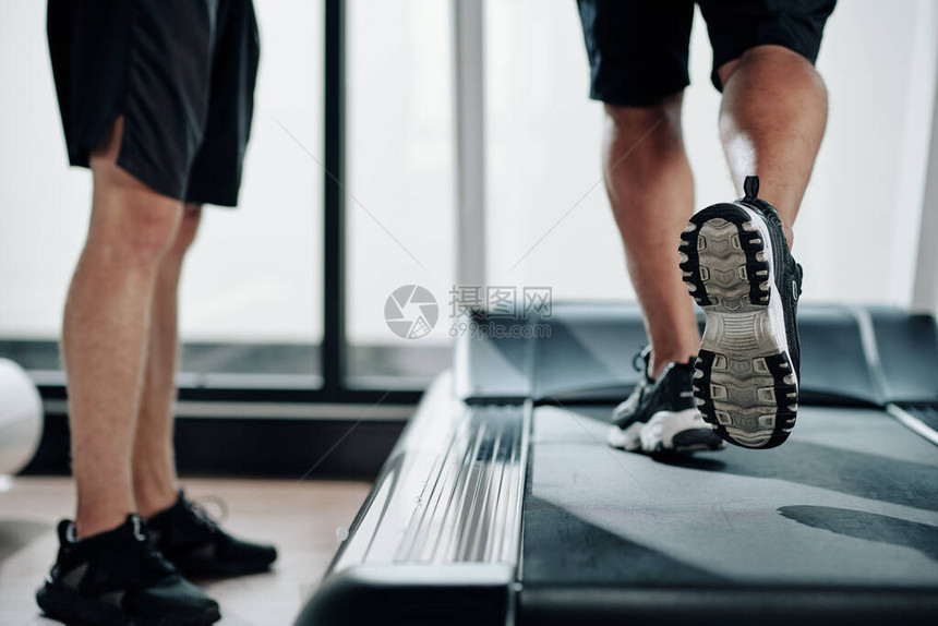 低段健身教练站在跑步机旁图片