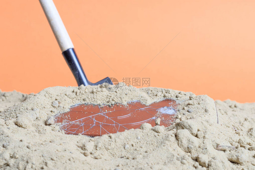 沙子里有一台破碎的智能手机在沙子里挖图片