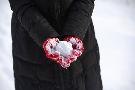 没有脸戴着红色冬季手套的女人手中的雪球图片