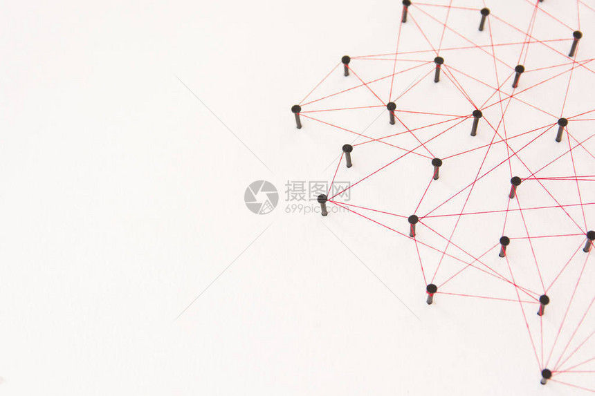 链接实体社交媒体通信网络两个网络之间的连接由黑钉和红线创建的具有复制空间的白纸图片