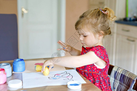 在流行冠状检疫疾病期间用手指颜色和马铃薯盖章绘画的幼儿小女孩背景图片