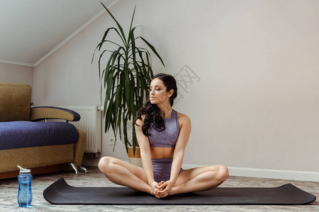 独立时在家瑜伽垫上练习运动服中的有图片