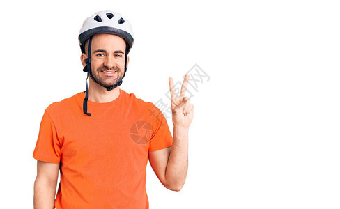 英俊的年轻人戴着自行车头盔笑着脸对着图片
