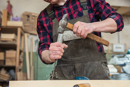木匠在木制车间里用凿子和锤子工作专业木工和手背景图片
