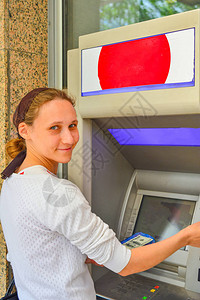 一名妇女将塑料卡插入自动取款图片
