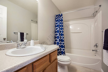 小浴室内部配有梳妆台和白色墙壁上的马桶浴缸和淋浴区有一个几何设图片