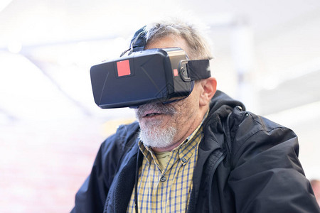 高级男子戴虚拟现实耳机眼镜虚拟现实展图片