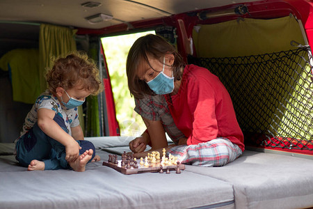 两名儿童在一辆野营车里下象棋图片