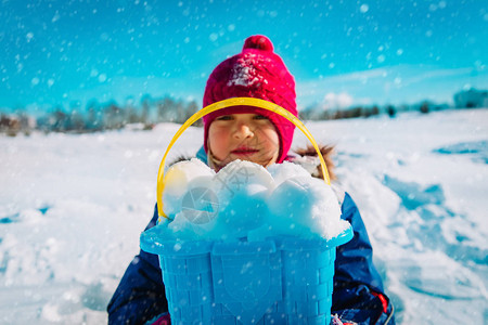 快乐的小女孩在冬天做雪球在冬季自然图片