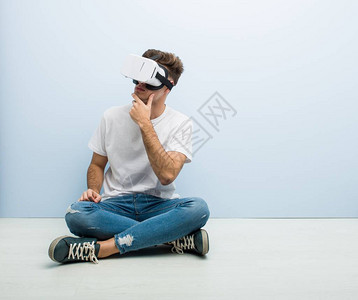 使用虚拟真实眼镜坐在地板上的人图片