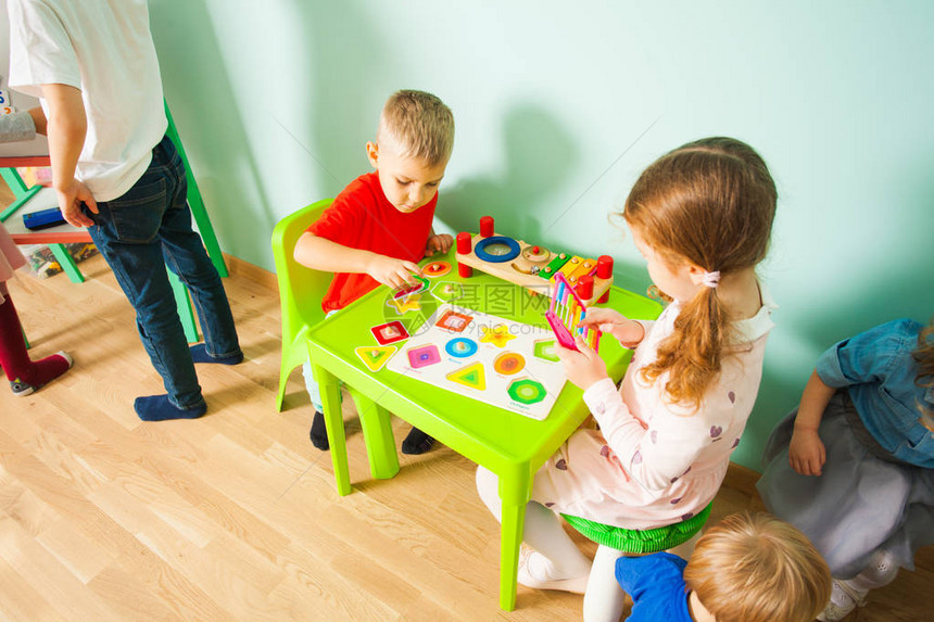 孩子们在玩磁板和字母在家上学的不同年龄的孩子教图片