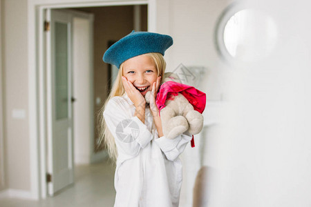 捕鱼达人游戏穿着白衬衫和蓝贝雷帽的漂亮时尚美发小姑娘手拿着玩具背景