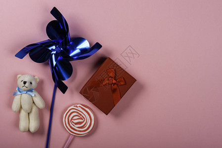粉红色背景的扁轮泰迪熊棒糖和礼品图像右背景图片