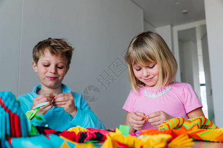 儿童在家中用纸做折纸手工艺儿图片