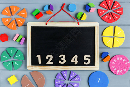 在灰色的木桌上用数字和多彩姿的数学分数关闭黑板儿童背景的有趣数学图片