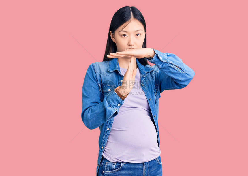年轻漂亮的孕妇怀孕婴儿用双手沮丧和严肃的图片
