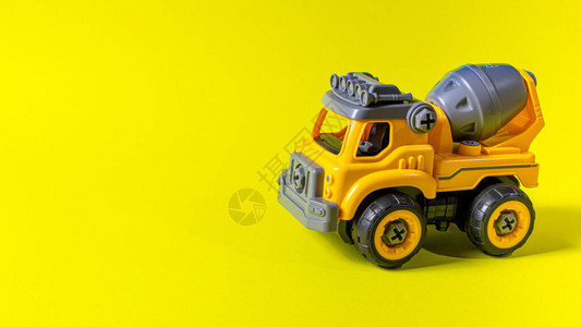 黄色背景的橙色混凝土搅拌机玩具打字机图片