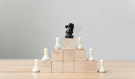 商业领导理念与顶部木块梯子楼梯上的国际象棋团队合作的图片