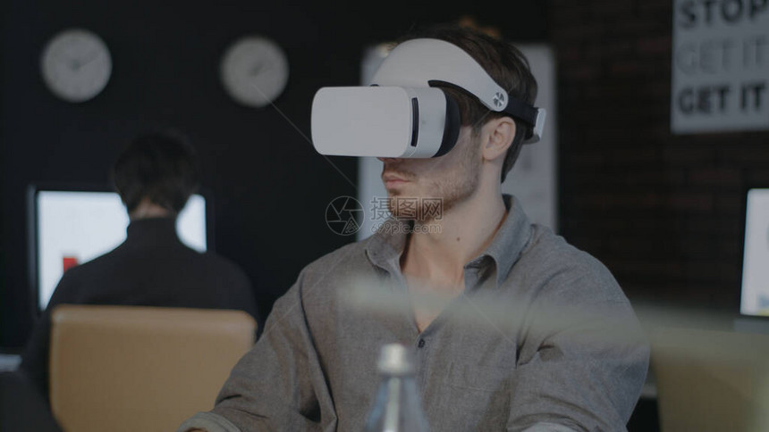 游戏设计师戴着VR耳机并在办公室从事增强现实工作坐在虚拟现实眼镜上的创意设计师带有眼镜的图片