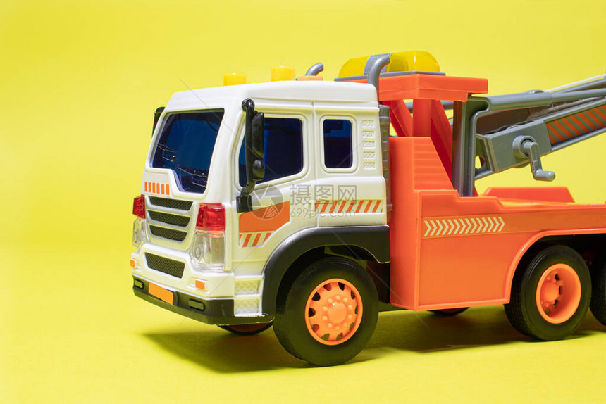 黄色背景横幅上的玩具橙色拖车图片
