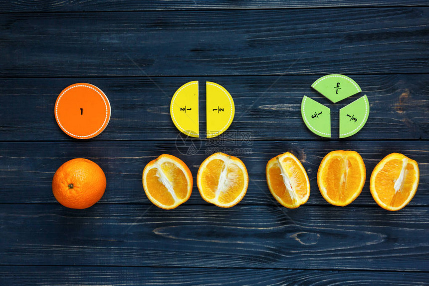 五颜六色的数学分数和橙子作为深色木制背景或桌子上的样本有趣的创意有趣的数学为孩子们教育图片