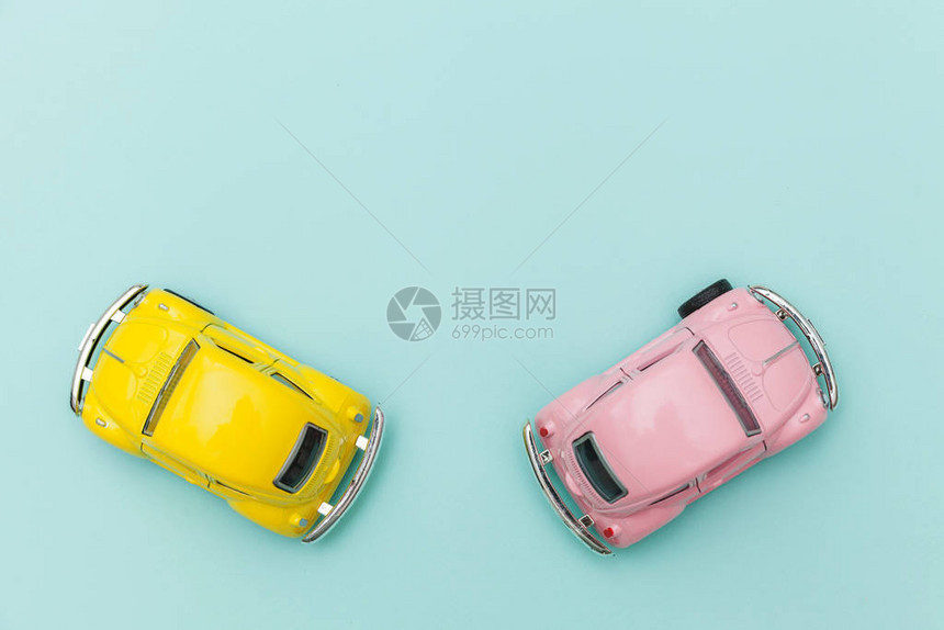 简单地设计与两个黄色粉红色复古玩具车隔离在蓝色柔和的彩色背景上汽车和交通标志城市交通付概念图片